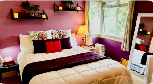 um quarto com uma cama com paredes roxas em Spacious & Comfortable, Private Queen Room & Bath in West Cloverdale em Surrey