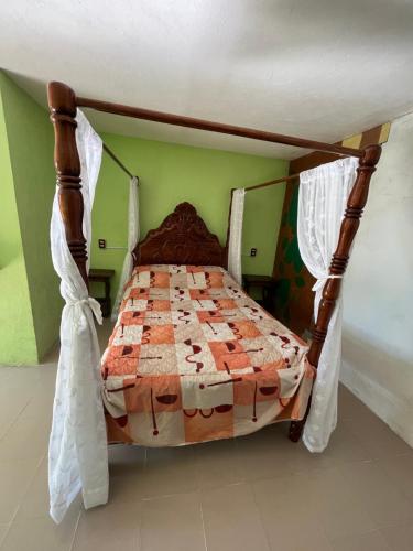 a bedroom with a bed with a wooden canopy at Hotel Villa Aventura in Cuetzalán del Progreso