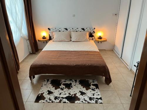 a bed in a room with two lamps and a rug at Къща за гости Куклите Петревене in Petrevene