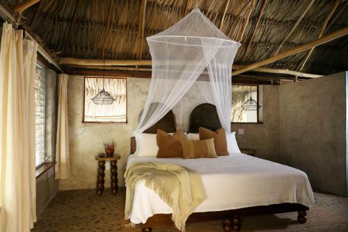 a bedroom with a bed with a mosquito net at Jade Jungle Resort in Teakettle Village