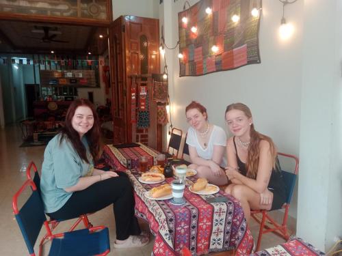 three girls sitting at a table eating food at Ha Giang Yolo House and Loop Tours in Ha Giang