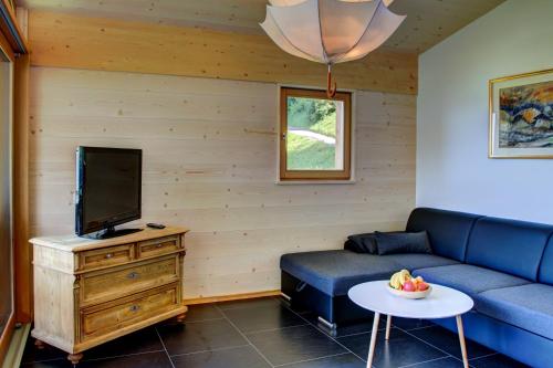 ein Wohnzimmer mit einem Sofa und einem TV in der Unterkunft Ratzeshof in Kastelruth
