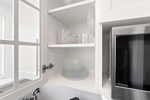 eine Küche mit einer Mikrowelle und einem Stapel Geschirr in der Unterkunft Conveniently located Studio in Burlington - U5 in Burlington
