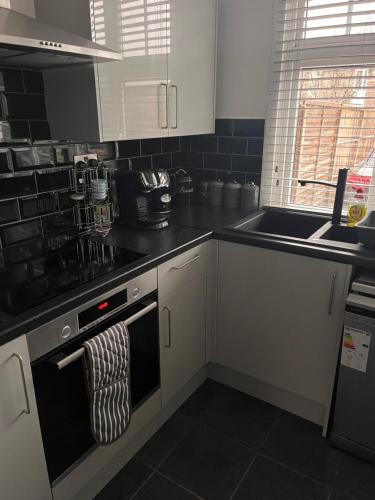a kitchen with a stove top oven and a sink at Eden Stays in Stivichall