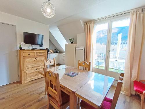 une cuisine et une salle à manger avec une table et une fenêtre dans l'établissement Le Marmandais, T3 lumineux duplex, balcon, parking, wifi, proche thermes, ascenseur, 4 personnes, à Luchon
