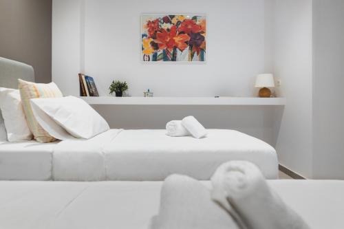 ein weißes Zimmer mit 2 Betten und einem Sofa in der Unterkunft Athens Soho Lofts -Evaggelistrias 18 in Athen