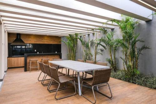 un tavolo e delle sedie in una stanza con delle piante di Apartamento Moderno - 8Km Aeroporto GRU a Guarulhos