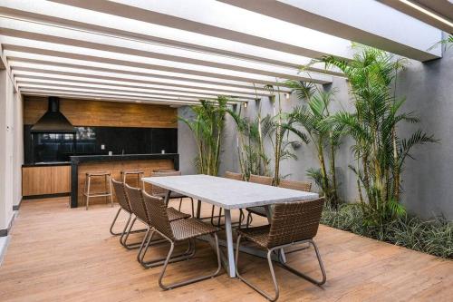 a table and chairs in a room with plants at Apartamento Novo Moderno-8Km Aeroporto GRU in Guarulhos