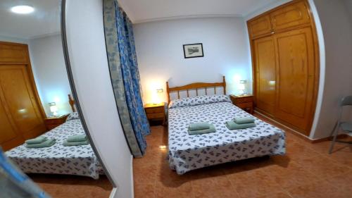 1 dormitorio con 2 camas y espejo en Sol Beach 24, en Playas de Orihuela