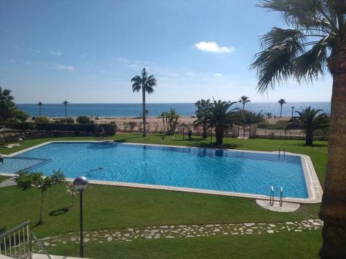 a large swimming pool with the ocean in the background at Top-Floor Beachfront Apartment with Parking, Pool, & Beautiful Sea-View Balcony in Villajoyosa