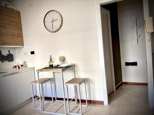 a kitchen with two stools and a clock on the wall at Civico 31 in Vercelli