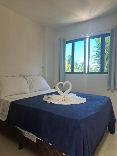a room with a bed with a ribbon on it at Flat Porto do Galo in Porto De Galinhas