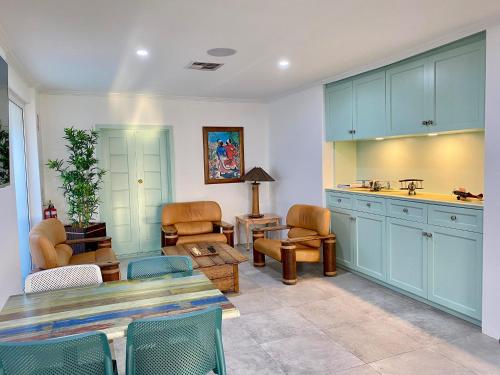 a kitchen with blue cabinets and a living room at Best Western Adelaide Airport in Adelaide