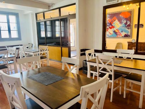 uma sala de jantar com mesas de madeira e cadeiras brancas em Nomada 870 - Hotel Work em Osorno