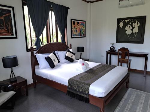 a bedroom with a bed with white sheets and pillows at Palmera Palma Garden Level in Moalboal