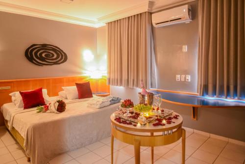 a hotel room with a bed and a table at Honorato Hotel by Easy Hotéis in Rio Verde