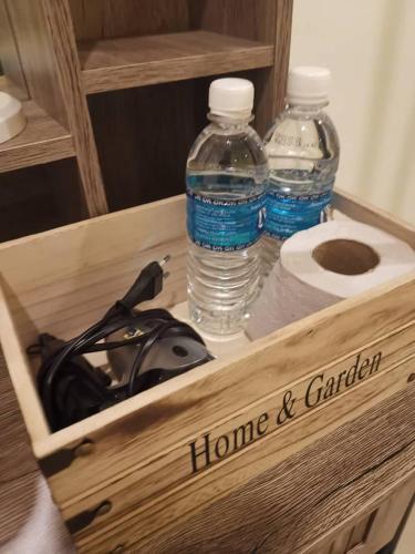 a wooden box with two bottles of water and toilet paper at Tawau Homestay W&T Cheap But Comfortable in Kampong Parit