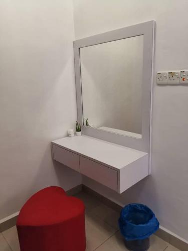 a bathroom with a mirror and a red stool at Tawau Homestay W&T Cheap But Comfortable in Kampong Parit
