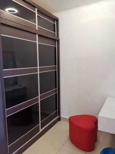 a room with a red stool and a glass closet at Tawau Homestay W&T Cheap But Comfortable in Kampong Parit