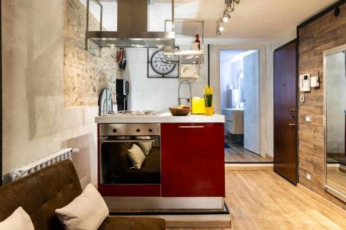 een keuken met een fornuis en een rode kast bij La Casa dello Stilista in Brescia
