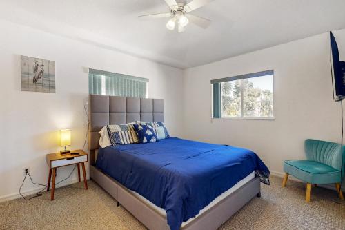 ein Schlafzimmer mit einem blauen Bett und einem blauen Stuhl in der Unterkunft Catch Me By The Sea in Clearwater Beach