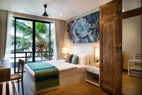 1 dormitorio con cama, escritorio y ventana en Villa Reef Talpe, en Talpe