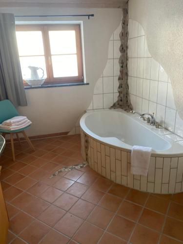 a bath tub in a bathroom with a window at Annahof in Argenbühl