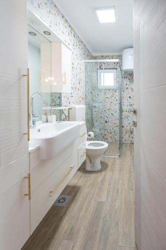 a bathroom with a white sink and a toilet at Calendula apartments in Tuzla
