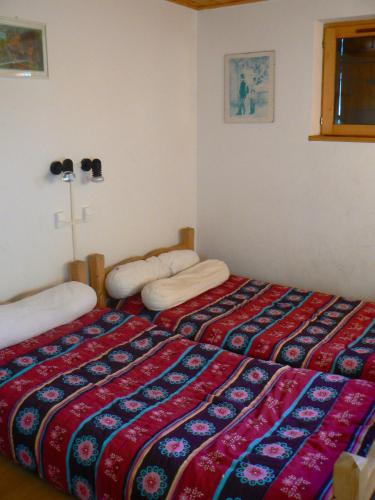 a bed in a room with a cross on the wall at Maison de charme à Séez avec vue sur montagne, cheminée in Séez