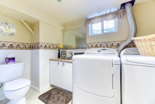 a bathroom with a washer and dryer and a toilet at First Place in Strathmore