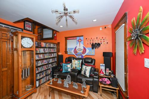 a living room with orange walls and a black leather couch at Berrodin Bed & Breakfast in Akron