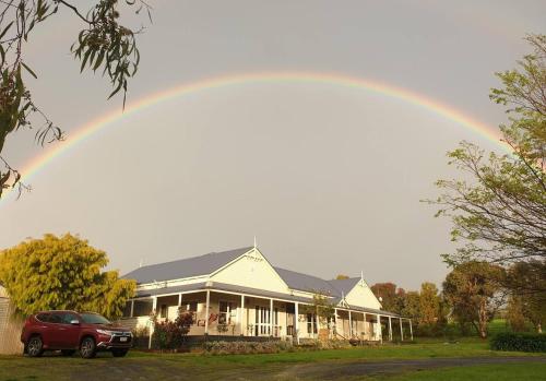 un arco iris sobre una casa con un coche aparcado delante en Jilly Park Farm Hands-On Experience Discover Authentic Farm Life Complimentary Breakfast Included en Buln Buln