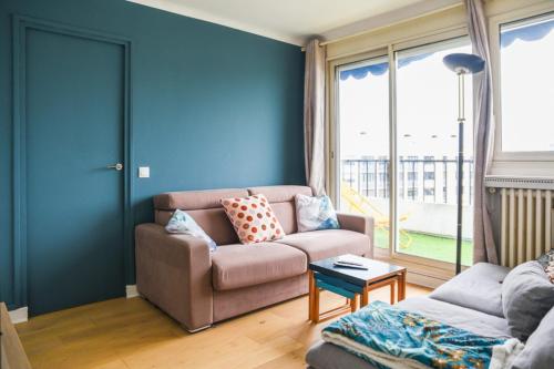 un salon avec un canapé et une table dans l'établissement 50 m unoverlooked nest with Eiffel Tower view, à Paris