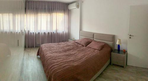 a bedroom with a large bed and a window at Central apartment - Cismigiu & Izvor Park in Bucharest