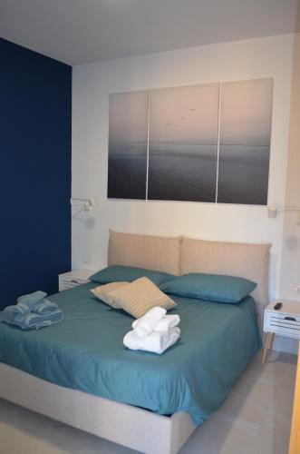 a bedroom with a bed with towels on it at Open Space Centralissimo Nettuno fronte Porto in Nettuno