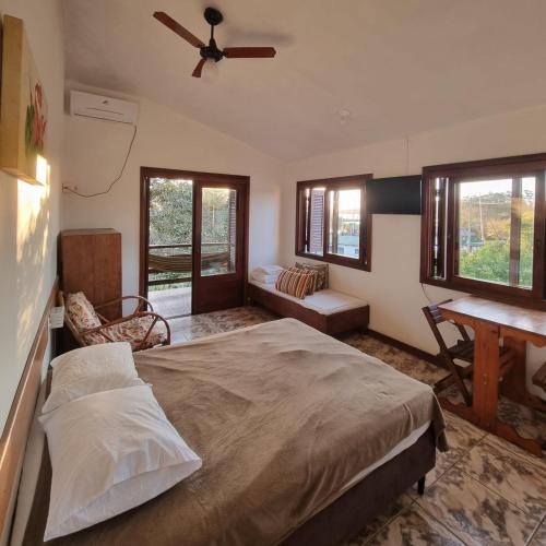a bedroom with a bed and a ceiling fan at Pousada dos Quiosques in Viamão