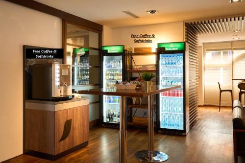 eine Bar in einem Restaurant mit zwei Kühlschränken in der Unterkunft Hotel Conti Dietikon in Dietikon