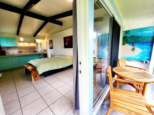 a bedroom with a bed and a table on a balcony at Arnott's Lodge & Hiking Adventures in Hilo