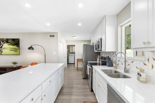 a white kitchen with white cabinets and a sink at Cozy-Perfect location-Private Pool-Heat Optional-SunsetFun-GCU in Phoenix