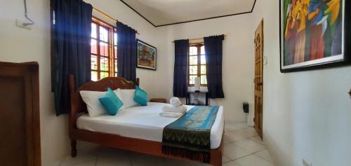 a bedroom with a bed and two windows at Private 1-BR Bungalow in Moalboal in Moalboal