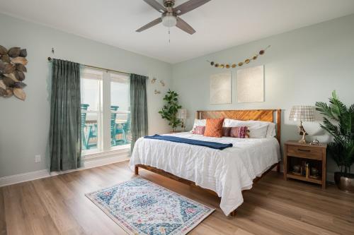 Un dormitorio con una cama y un ventilador de techo. en Unobstructed Panoramic Beachfront 4 BD*Sleeps 14!, en Crystal Beach