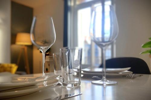 une table avec deux verres à vin et des assiettes dessus dans l'établissement Le Solar-Appart lumineux proche centre et gare, au Havre