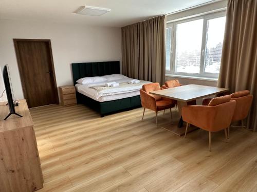 Cette chambre comprend un lit, une table et des chaises. dans l'établissement Apartmány Loky, à Košice