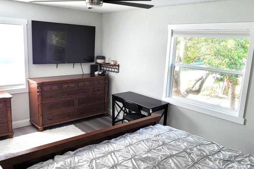 a bedroom with a bed and a flat screen tv at House close Baldwin-park Lake & Downtown Orlando in Orlando