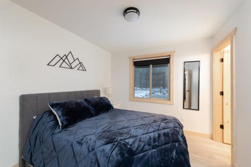 a bedroom with a bed and a window at The Alpine Cabin in Valemount