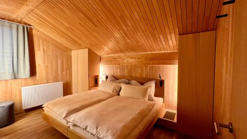 um quarto com uma cama e um tecto em madeira em Naturhaus Loacker em Lech am Arlberg