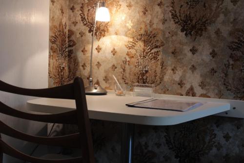un bureau avec une chaise et une lampe sur un mur dans l'établissement Kleine Wohnung im Grünen, à Hambourg