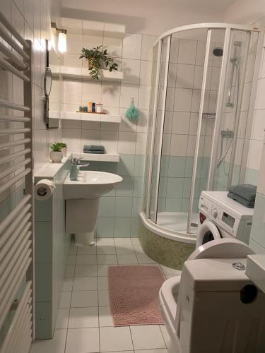 uma casa de banho com um chuveiro, um lavatório e um WC. em City Apartment em Piešťany