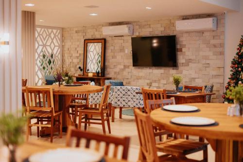 restauracja z drewnianymi stołami i krzesłami oraz choinką świąteczną w obiekcie Casa Cancun Eventos e Hotel Boutique w mieście Penha