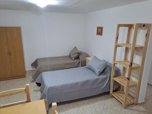 Habitación con cama y estante para libros en Complejo Lucero en Santa Rosa